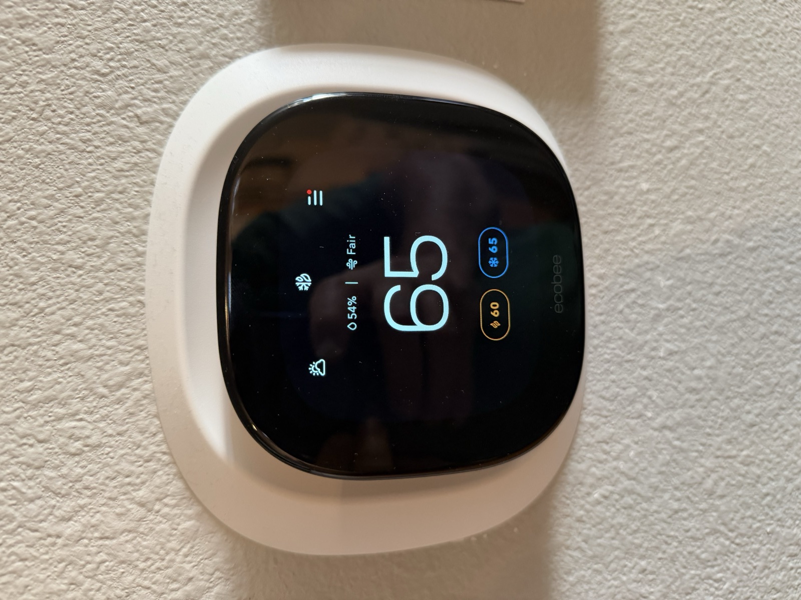 Ecobee smart thermostat on the wall showing temperature and an air-quality reading.