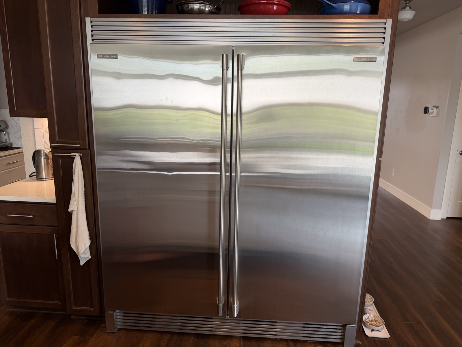 Electrolux ICON built-in refrigerator and freezer column pair, stainless steel doors with matching handles, under a shared louvered grille.