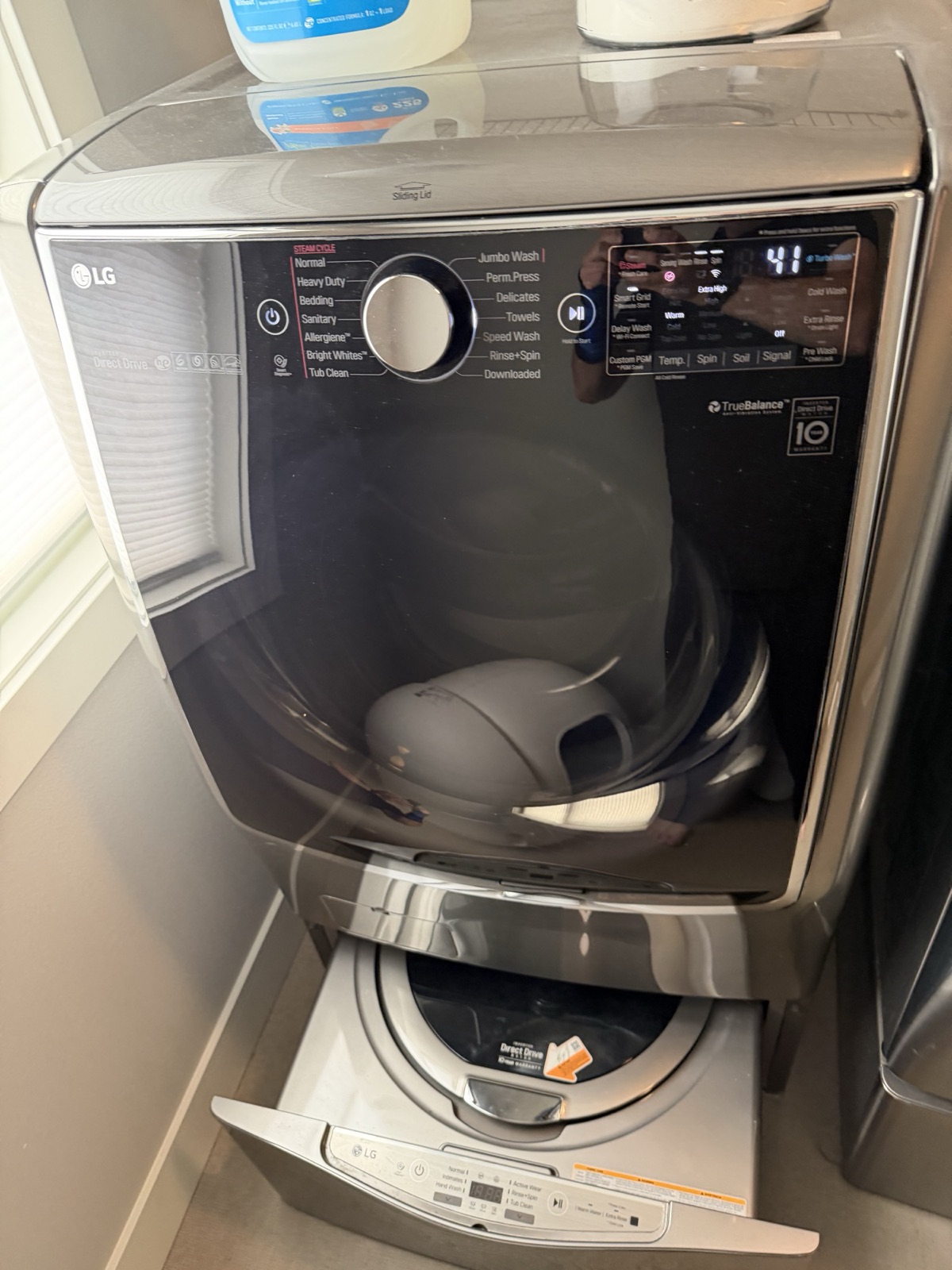 LG front-load washer with an on-door control panel showing Jumbo Wash, TurboWash, and TrueBalance branding, with the matching dryer visible alongside.